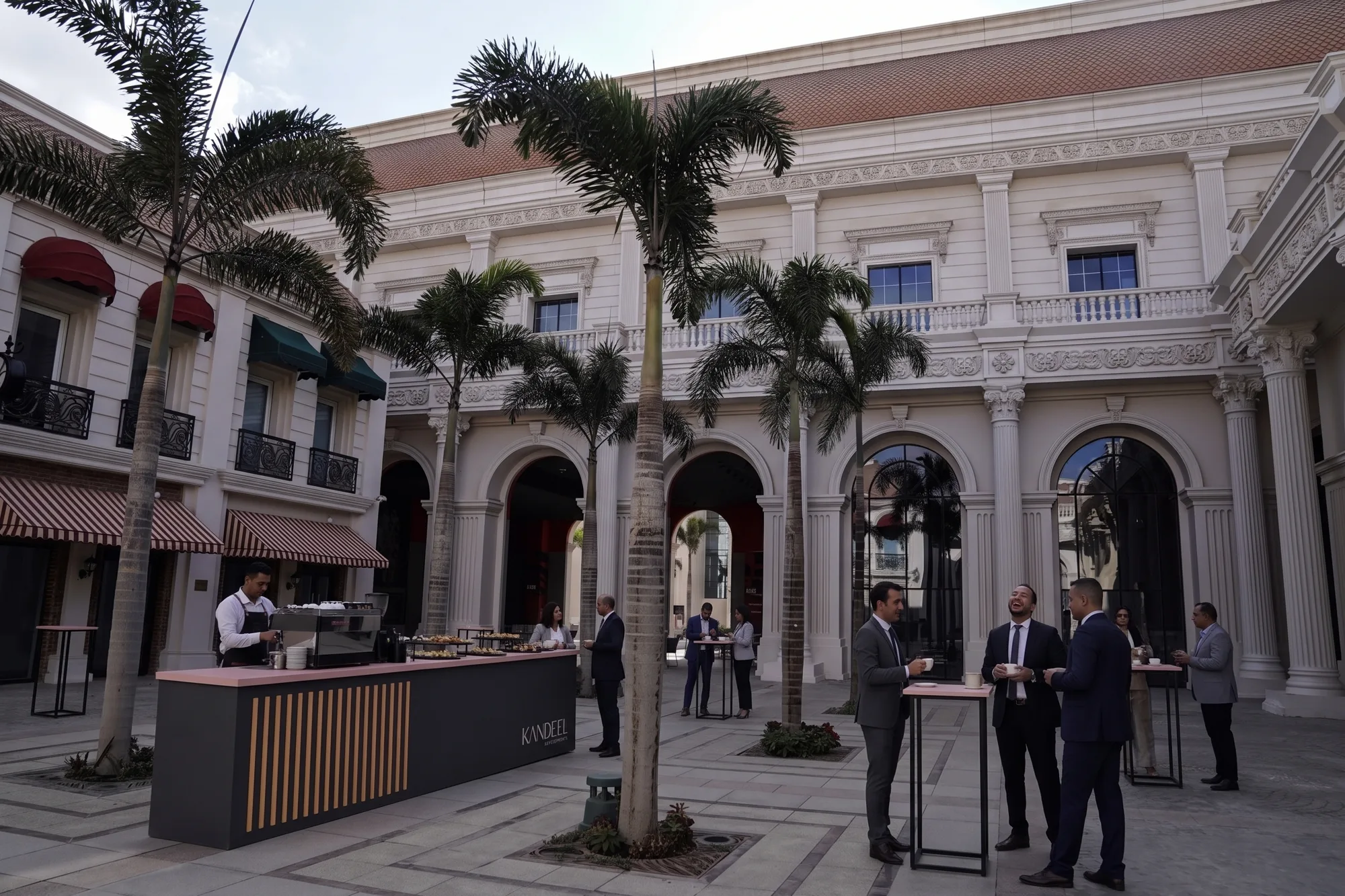 Charcoal and Dawn Pink coffee and canapé bar with high tables in the palm courtyard